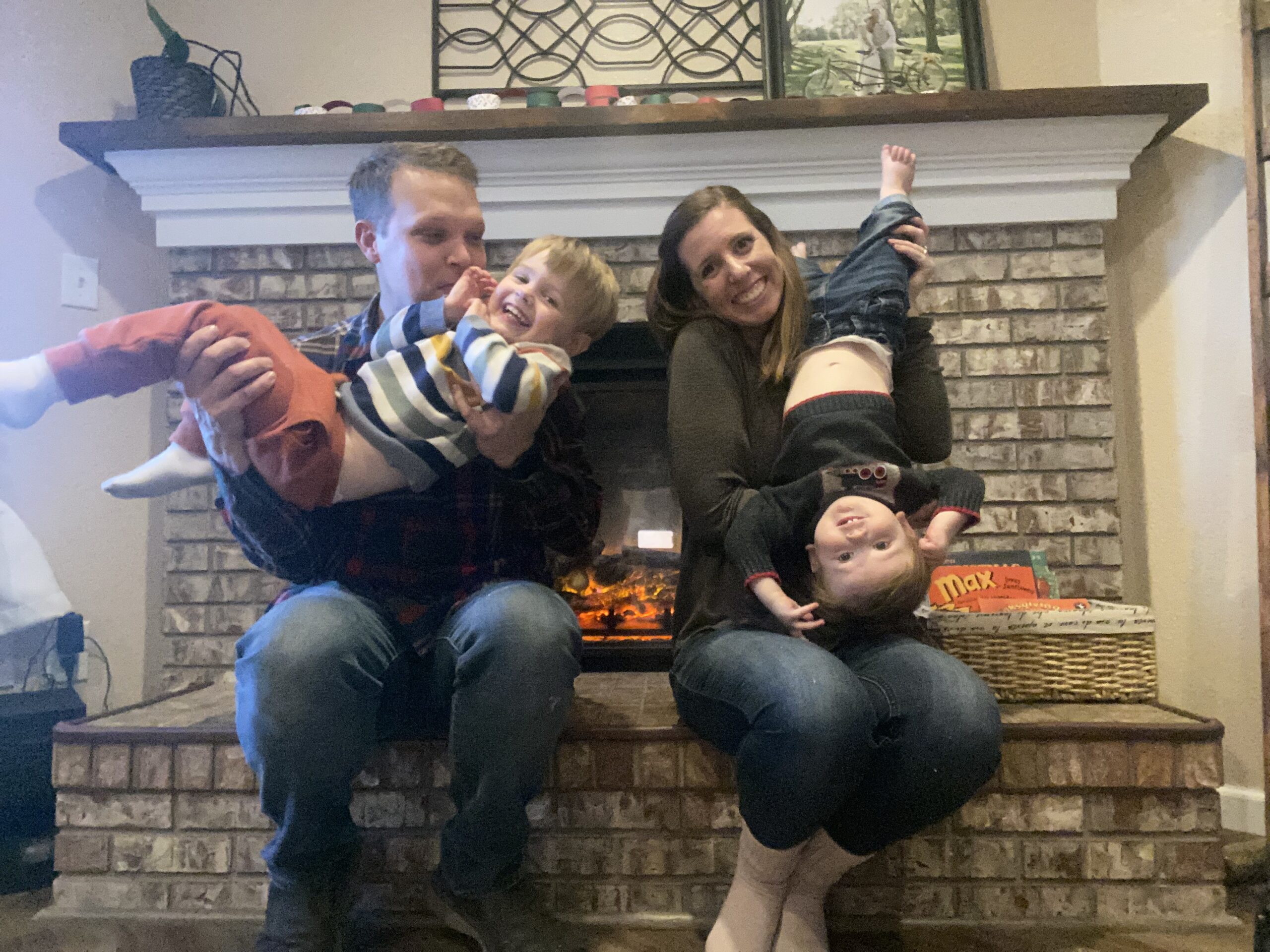 Matthew Long and family sitting by a fireplace