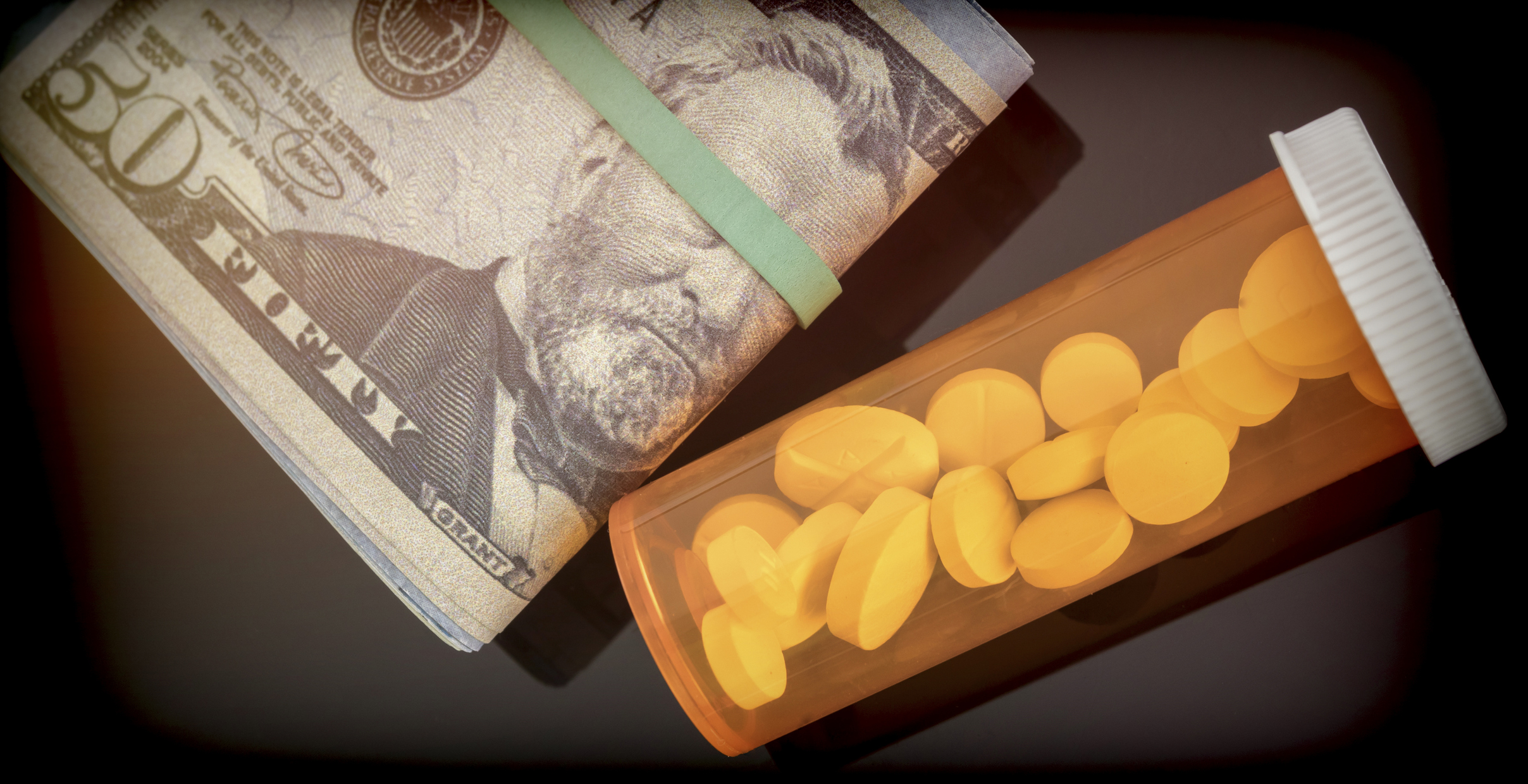 bottle of white pills along with dollar bills, concept of copayment