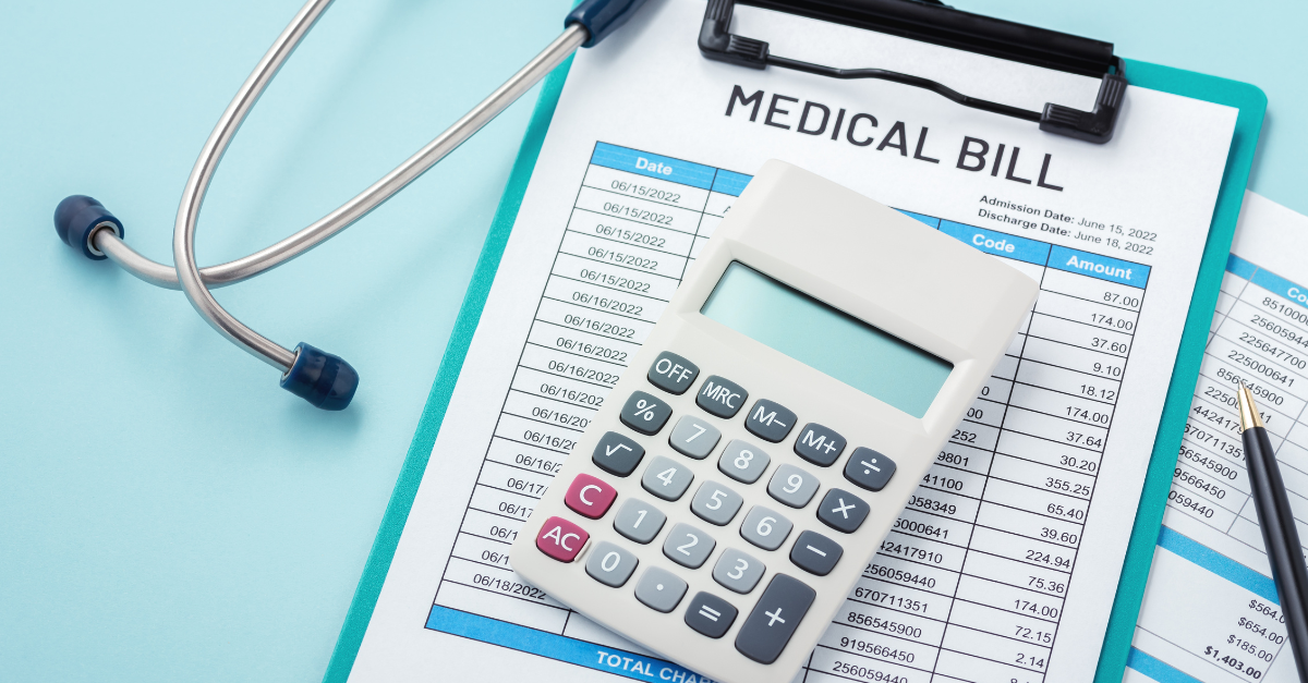 Photo of hospital bill on a clip board, surrounded by calculator and stethoscope